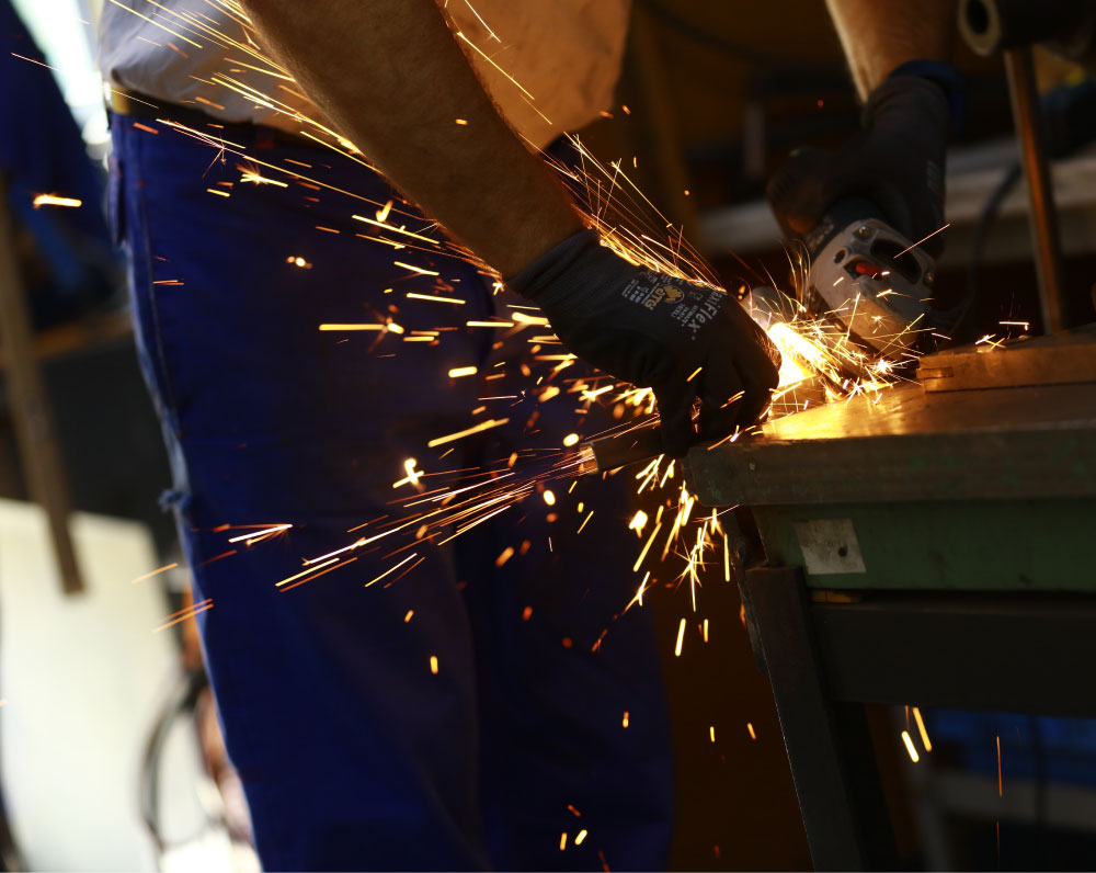 Mitarbeiter in der Leipziger Rollstuhlmanufaktur Br&auml;unig schneidet Rohre f&uuml;r einen Zimmerrollstuhl zurecht 