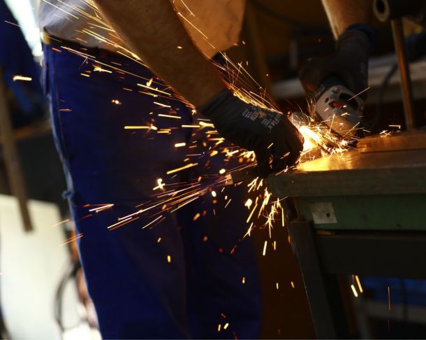 Mitarbeiter in der Leipziger Rollstuhlmanufaktur Br&auml;unig schneidet Rohre f&uuml;r einen Zimmerrollstuhl zurecht 