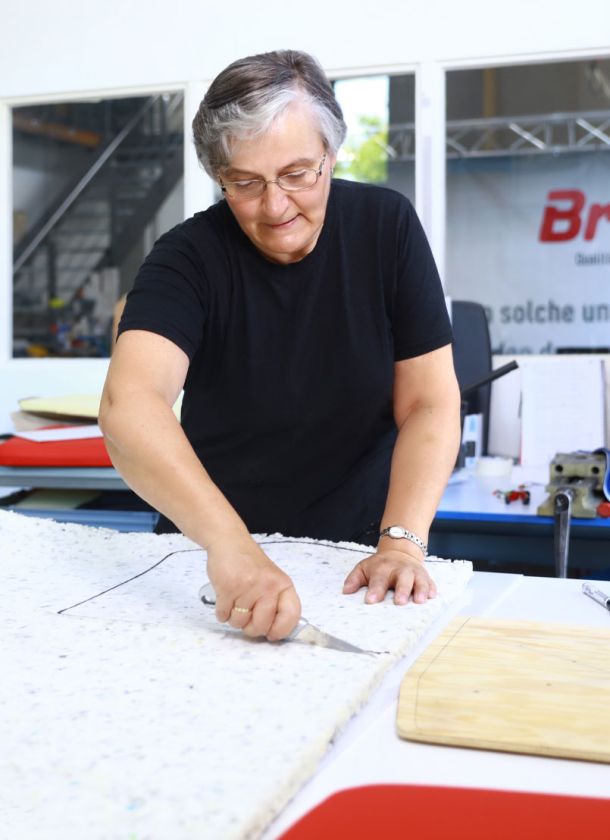 N&auml;herin zeichnet mit einer Schablone das Sitzpolster an